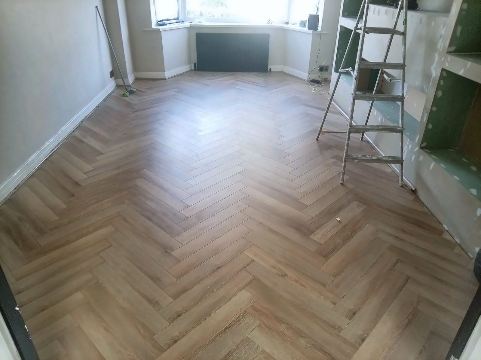 Newly laid herringbone floor in a bay-windowed room